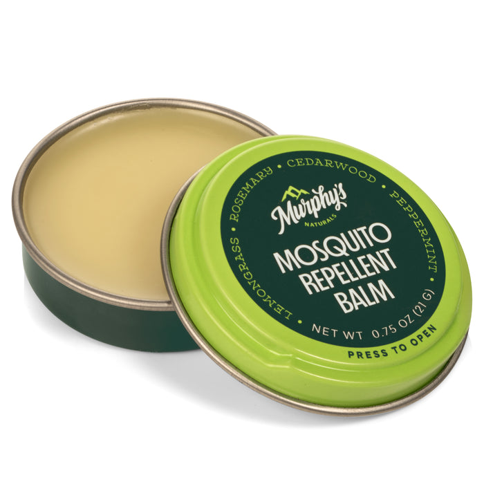 A round tin of Murphy’s Naturals Mosquito Repellent Balm with a green lid partially open, revealing the light yellow balm inside. The lid lists ingredients like rosemary, cedarwood, peppermint, and lemongrass.