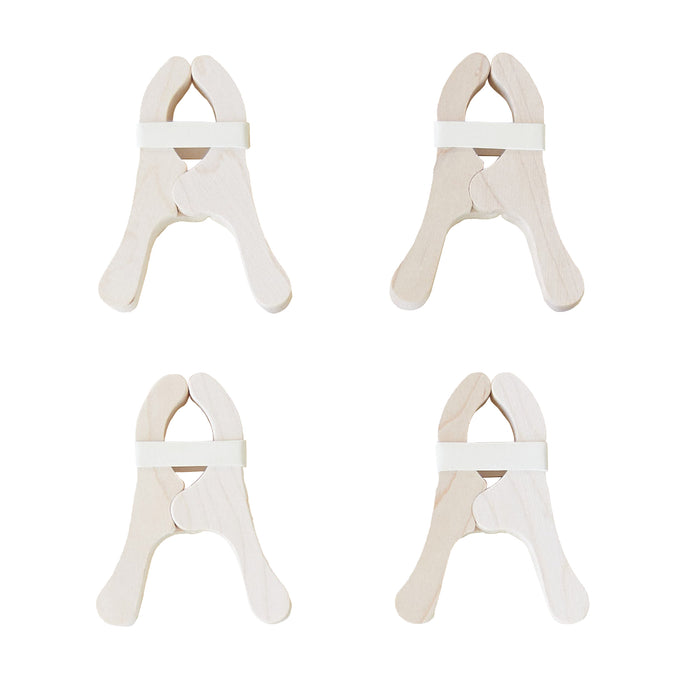 Four Play Clips from Sarahs Silks, featuring a minimalist design with rounded edges and light beige color, are arranged in a 2x2 grid. Each peg is secured by elastic bands near the top, making them ideal for creative playsilk fort-building adventures.