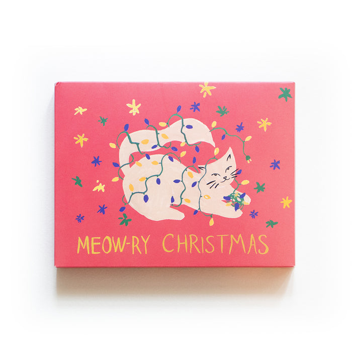 A pink card featuring an illustrated white cat tangled in colorful Christmas lights, surrounded by yellow stars, with the text MEOW-RY CHRISTMAS written below in yellow letters.