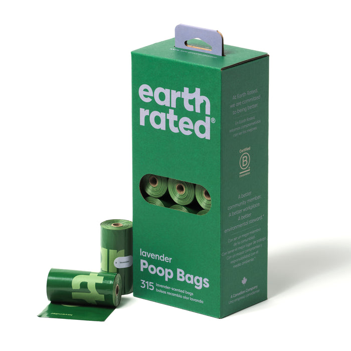 A green box labeled earth rated lavender Poop Bags with a handle, partially open to reveal rolled green bags inside. Three rolled poop bags are displayed in front of the box.