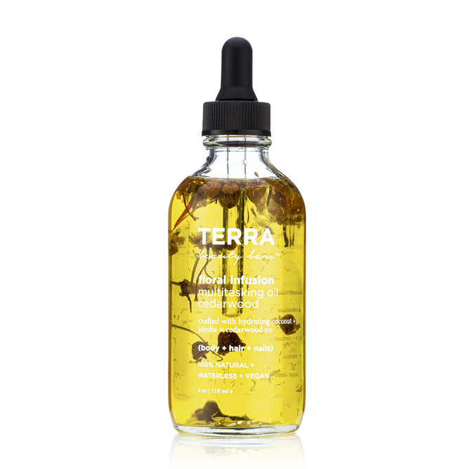 The Floral Infusion Multitasking Oil by Terra Beauty Bars comes in a clear dropper bottle, enriched with cedarwood and natural oils like coconut and jojoba. This vegan, waterless oil is enhanced with visible dried flowers, ideal for elevating your self-care routine for body, hair, and nails.