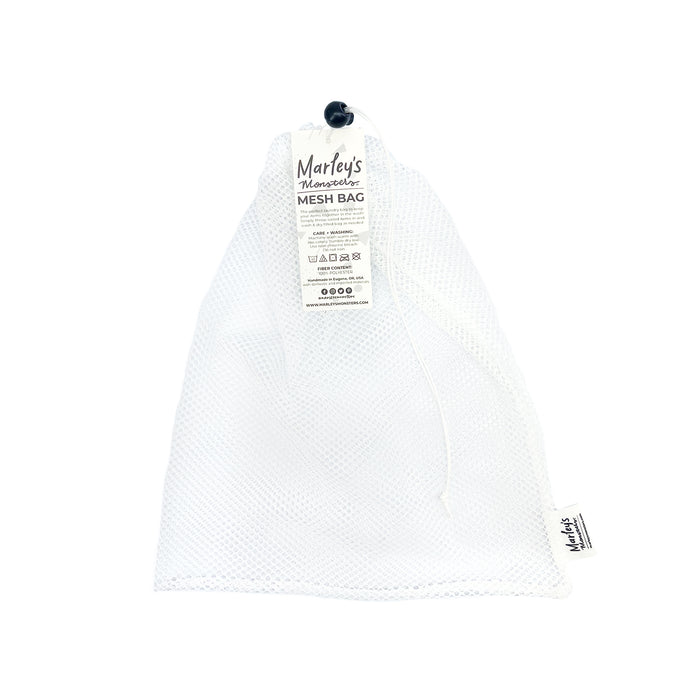 A reusable white mesh bag with a drawstring and a label reading Marley’s Monsters Mesh Bag attached to the top, displayed on a plain white background.