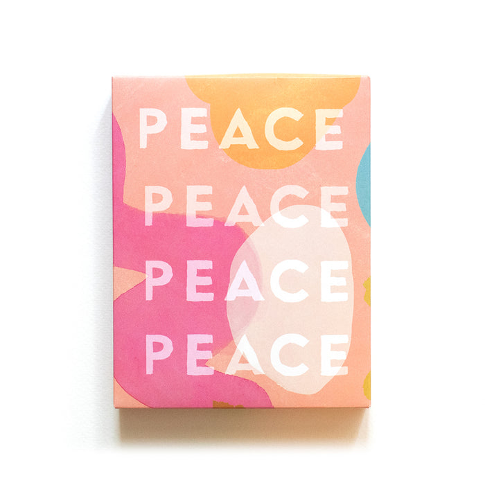 A rectangular box with a colorful abstract pattern in pink, orange, yellow, and blue hues. The word PEACE is repeated four times in bold white letters across the front.