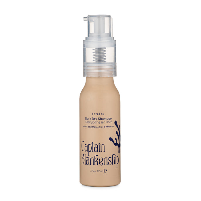 A beige bottle of Captain Blankenship Dark Dry Shampoo with a pump dispenser and dark blue text and design on the front, standing upright against a white background.