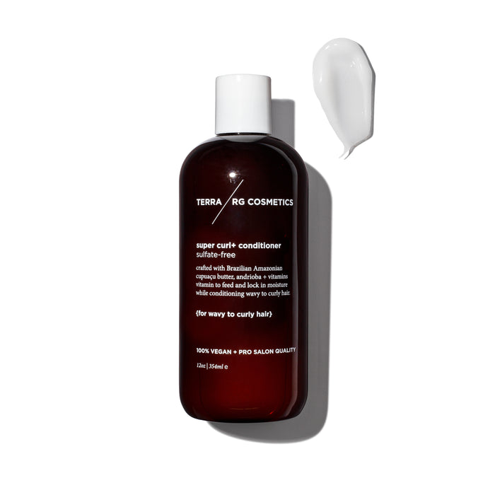 A dark amber bottle labeled TERRARG COSMETICS super curl+ conditioner sits next to a dollop of white conditioner on a white background. The bottle features white text with product details.