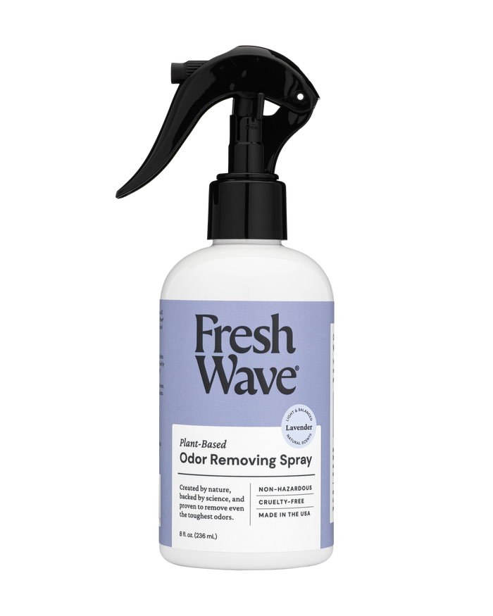 A bottle of Fresh Wave Plant-Based Odor Removing Spray in lavender scent, featuring a black trigger spray top and a white and purple label with product information and branding.