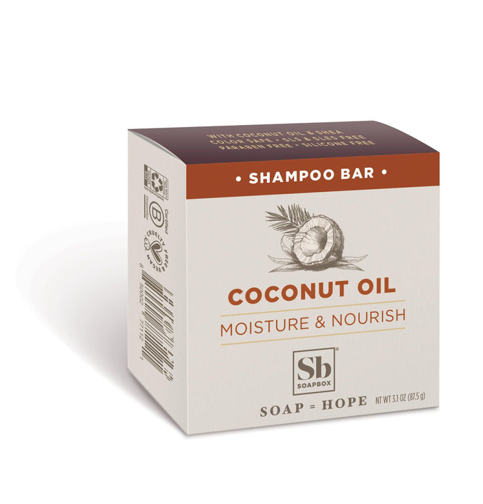 A box of Soapbox Coconut Oil Shampoo Bar, featuring an illustration of a coconut and text that reads Moisture & Nourish. The packaging is beige with brown accents and includes the Soapbox logo.
