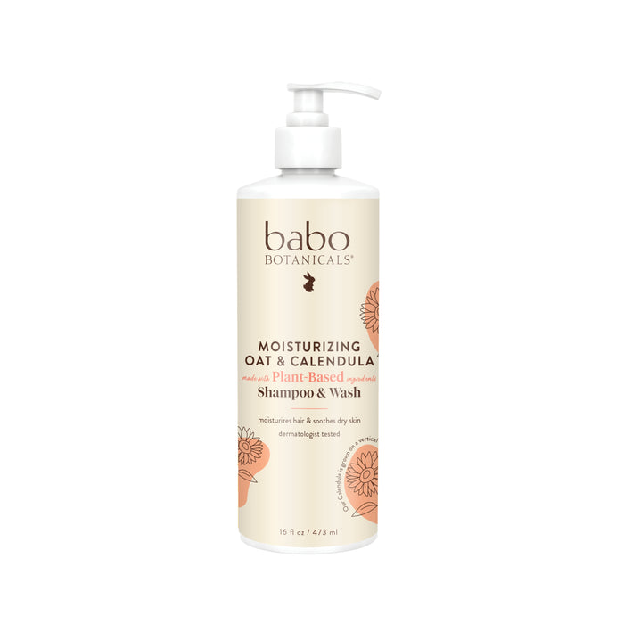 A bottle of Babo Botanicals Moisturizing Oat & Calendula Plant-Based Shampoo & Wash with a pump dispenser, decorated with illustrations of flowers on a beige and white label. The bottle size is 16 fl oz (473 ml).