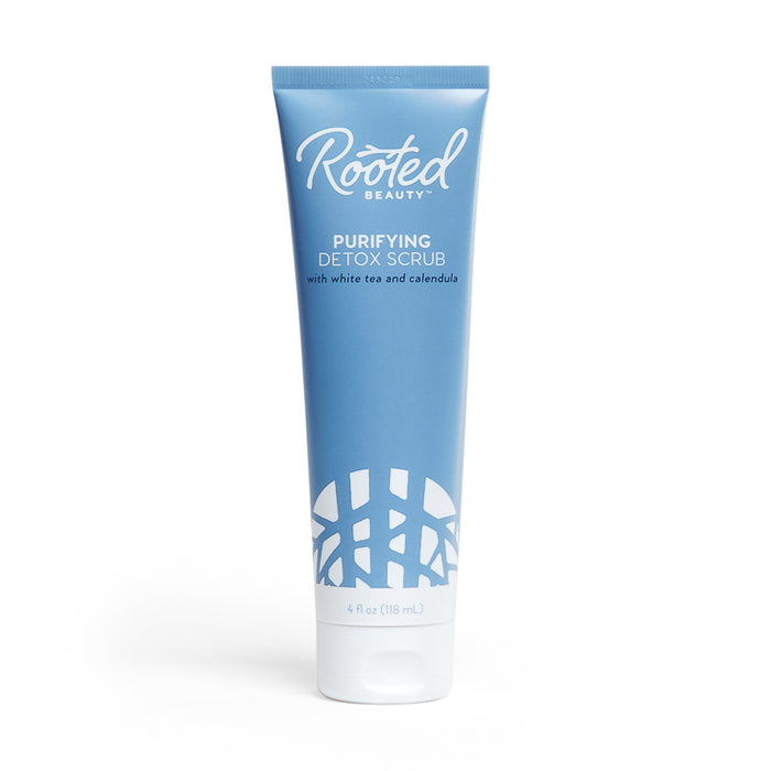 A blue tube of Rooted Beauty Purifying Detox Scrub with white tea and calendula, featuring white text and a white abstract design at the bottom. The tube contains 4 fl oz (118 mL) of product.