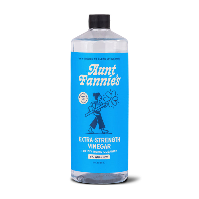 A bottle of Aunt Fannie’s Extra-Strength Vinegar for DIY home cleaning, 6% acidity. The bottle has a blue label with a woman holding a spray mop illustration and white text.