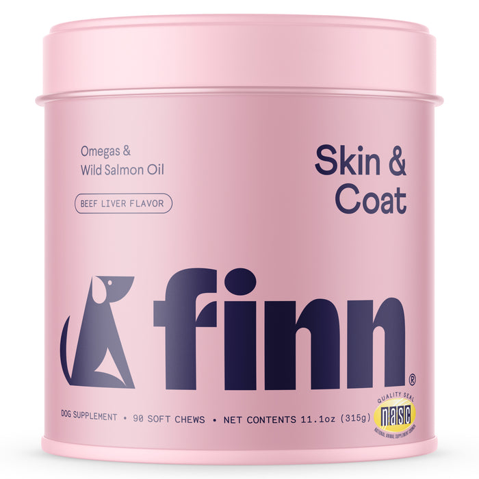 A pink container labeled finn Skin & Coat dog supplement, featuring a dog silhouette graphic. The product contains omegas and wild salmon oil, is beef liver flavored, and includes 90 soft chews.