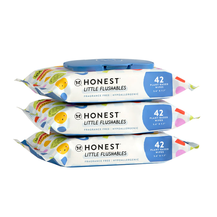 Three stacked packs of Honest Little Flushables wipes, each with a blue flip-top lid. The packaging is decorated with colorful shapes and lists features like fragrance free and 42 plant-based wipes.
