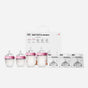 A set of four Comotomo baby bottles with pink lids and silicone nipples is displayed in front of a white box labeled Baby Bottle Bundle. Three packs of replacement nipples are arranged to the right of the bottles.