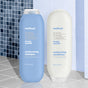 Two bottles of Method hair care products stand side by side on a tiled surface—one blue shampoo bottle and one white conditioner bottle—both labeled “simply nourish” with coconut, rice milk, and shea butter.