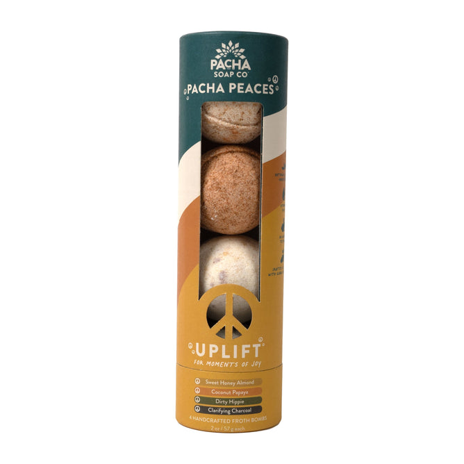 Pacha Soap Co.s Calm Collection features a cylindrical package of handcrafted Pacha Peaces soap bars. Adorned with earthy tones and a peace symbol, it reads Uplift and For Moments of Joy.