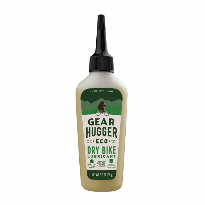 A bottle of Gear Hugger Eco Dry Bike Lubricant with a pointed nozzle cap, featuring a green label showing a cyclist and trees. The bottle contains 3.2 oz (90 g) of lubricant.