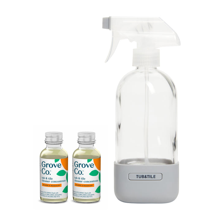 The Tub & Tile Cleaner Starter Set by Grove Co. includes a reusable glass spray bottle labeled Tub & Tile with a gray base, accompanied by two small concentrate bottles showcasing green labels and plant-based ingredients.