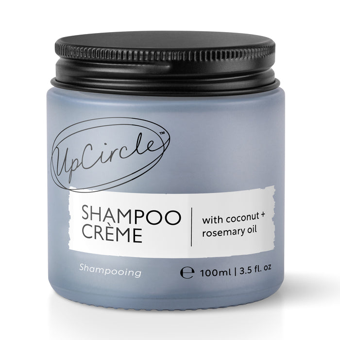 A blue jar of UpCircle Shampoo Crème with a black lid. The label reads Shampoo Crème with coconut + rosemary oil, 100ml | 3.5 fl. oz.