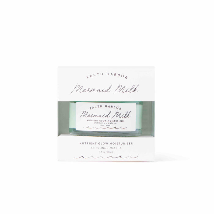 A box of Earth Harbor Mermaid Milk Nutrient Glow Moisturizer, featuring a clear window showing the product jar inside. The packaging is white with teal accents and elegant script font.