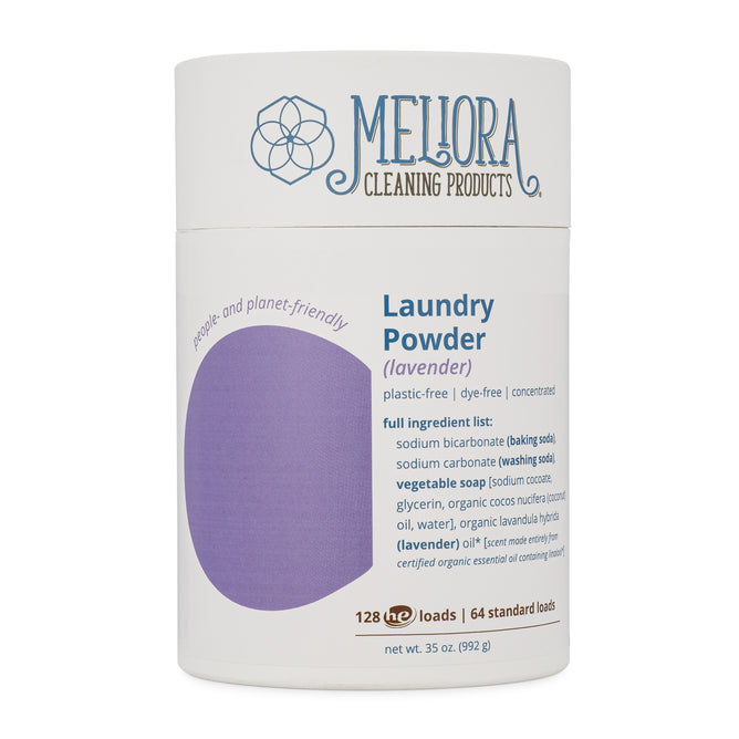 A cylindrical container of Meliora Cleaning Products Laundry Powder (lavender scent). The label highlights its plastic-free, dye-free, and lists ingredients. The container makes 128 HE or 64 standard loads. Net weight: 35 oz (992 g).