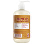 A pump bottle of Mrs. Meyer's Hand Soap features a beige and brown label with garden-inspired accents, contains essential oils, and is free from parabens, phthalates, MEA/DEA, and artificial colors.