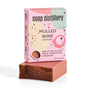 A bar of reddish-brown soap sits in front of a pink and green Soap Distillery box labeled “Mulled Wine Bar Soap.” The box notes scents of mulling spices, orange peel, and cardamom.
