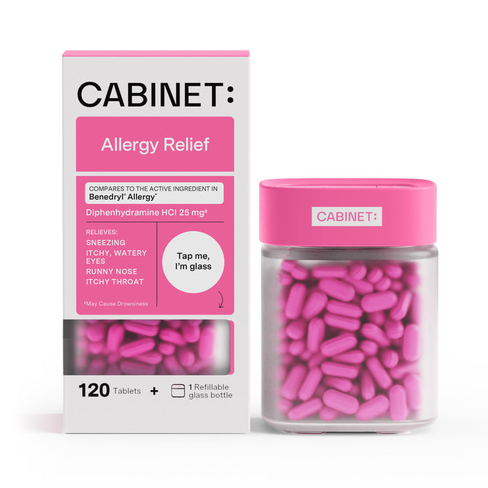 A box and glass bottle of Cabinet Allergy Relief tablets, with pink capsules visible inside the bottle. The packaging highlights relief for sneezing, watery eyes, runny nose, and itchy throat.