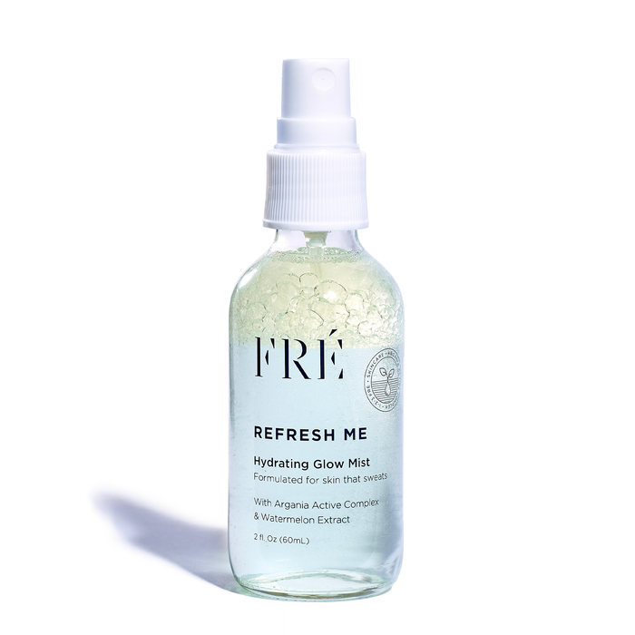 A clear spray bottle labeled FRÉ REFRESH ME Hydrating Glow Mist with a white pump, containing a light green liquid and floating gel bubbles. The bottle holds 2 fl oz (60mL) and sits on a white background.