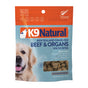 A bag of K9 Natural New Zealand Grass-Fed Beef & Organs Healthy Bites dog treats. The package is blue and orange, features a golden retriever, and displays information about the treats being grain-free and high in protein.