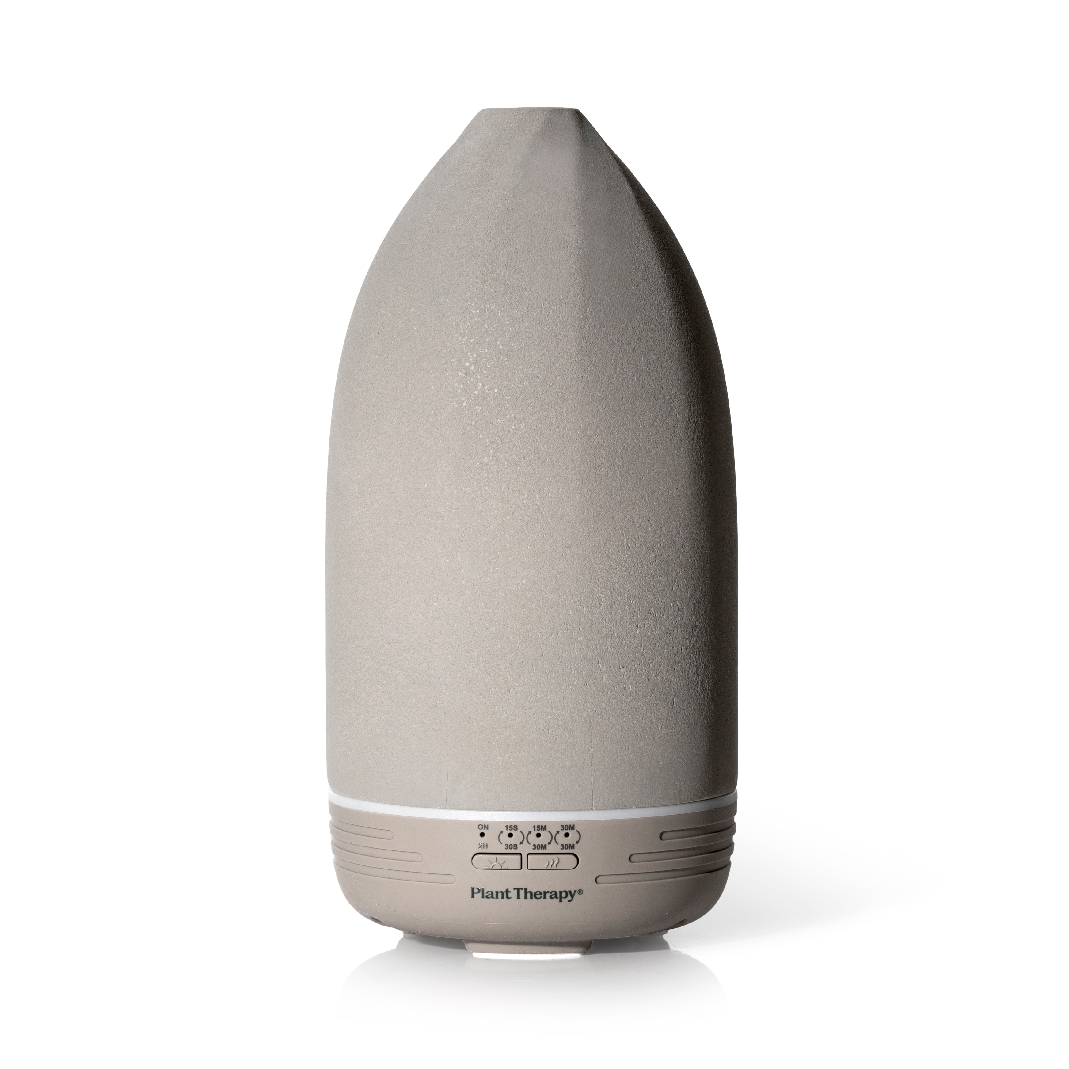 The Metro Stone Diffuser by Plant Therapy is a sleek gray ceramic device with a pointed top and white base, featuring control buttons. It elegantly stands on a white surface, ready to infuse your space with essential oils.