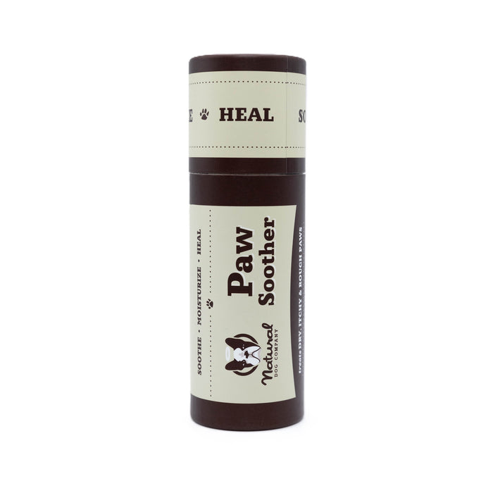 A brown and beige tube labeled Paw Soother from Natural Dog Company, designed for moisturizing and healing dogs’ paws, is shown standing upright against a white background.