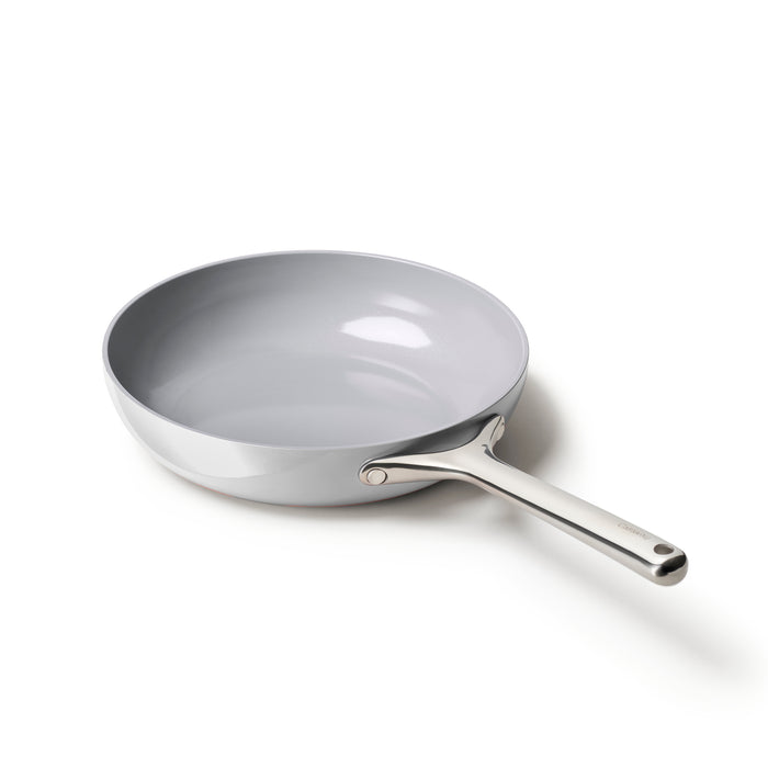 A stainless steel frying pan with a shiny silver interior and a long handle, shown on a white background.