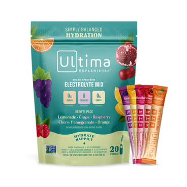 A green Ultima Replenisher electrolyte mix bag with fruit images and five colorful single-serve stick packs (lemonade, grape, raspberry, cherry pomegranate, orange) displayed beside it.
