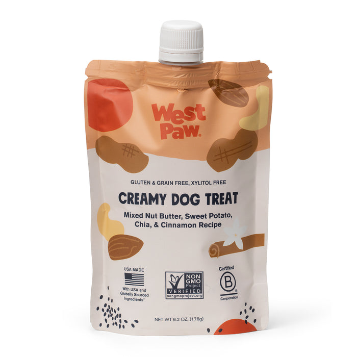 A pouch of West Paw Creamy Dog Treat in mixed nut butter, sweet potato, chia, and cinnamon flavor. The package highlights that it is gluten and grain free, and displays certification and ingredient icons.