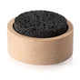 A Plant Therapy Lava Rock Passive Diffuser, featuring a round black lava rock set in a light wooden holder, is displayed on a white background.