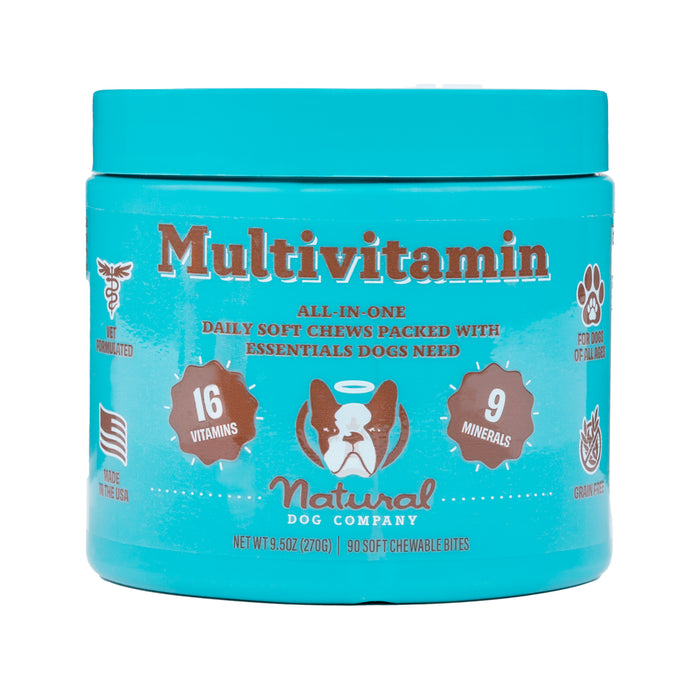 A blue container of Natural Dog Company Multivitamin soft chews for dogs, highlighting 16 vitamins and 9 minerals, with icons for vet formulated, made in the USA, dog paw, and grain-free features.