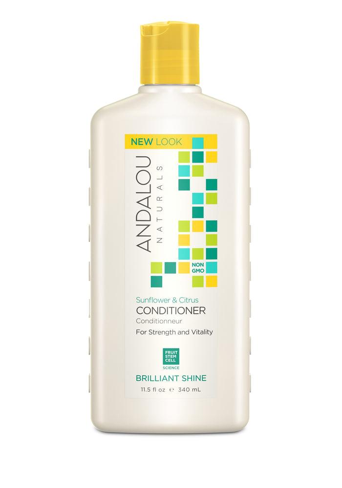A white bottle of Andalou Naturals Sunflower & Citrus Conditioner for brilliant shine, featuring yellow, green, and blue square designs and text indicating it is non-GMO and provides strength and vitality.