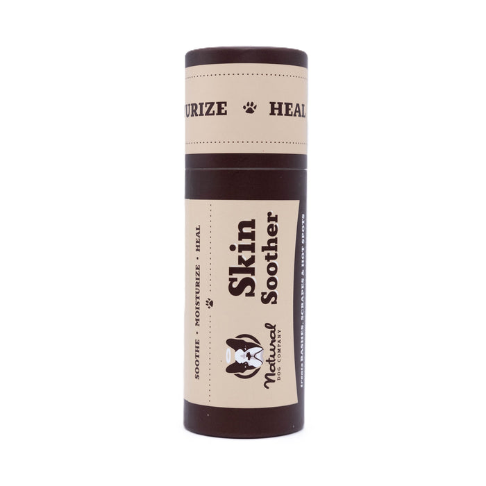 A brown cylindrical tube labeled Skin Soother by Natural Dog Company, designed for soothing, moisturizing, and healing skin, with paw prints and product information on the packaging.