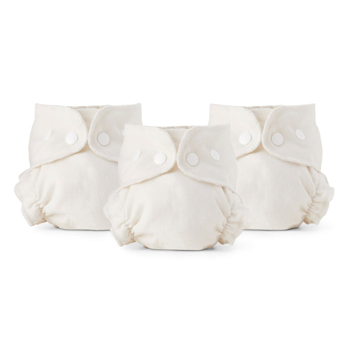 Three cream-colored reusable cloth diapers with snaps are displayed side by side against a white background.