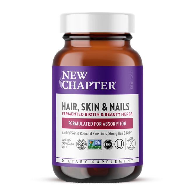 A brown bottle of New Chapter Hair, Skin & Nails dietary supplement with a purple and white label, highlighting biotin, beauty herbs, and absorption benefits. The label includes various certifications and 60 capsules.