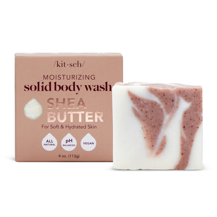 A bar of shea butter solid body wash with a pink and white marbled appearance is placed next to its packaging, which is light brown and labeled Moisturizing Solid Body Wash, Shea Butter, For Soft & Hydrated Skin.