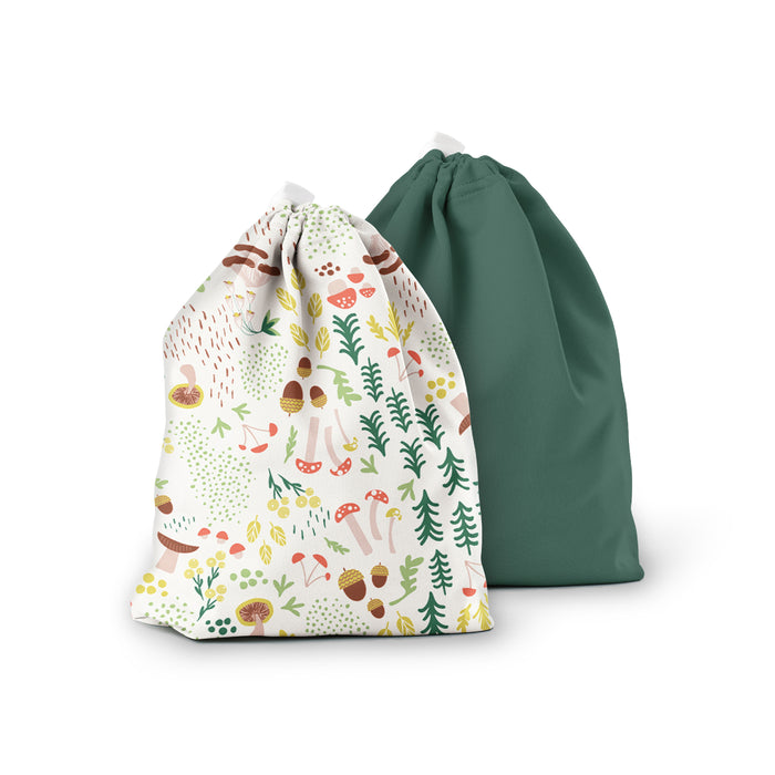 The Ditty Bag Duo Wet Bags by Esembly Baby are displayed against a white background. The front bag features colorful illustrations of mushrooms, leaves, and berries, while the back bag is solid forest green. Both bags are crafted from recycled plastic.