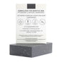 The Activated Charcoal Facial & Body Bar from Little Seed Farm is an unscented black soap made with organic, natural ingredients, designed for sensitive and acne-prone skin. It sits in front of its branded box.