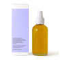 Little Seed Farm Body Oils come in a clear glass pump bottle filled with golden oil, next to a white and light purple box noting ingredients like hazelnut, hemp seed oil, and lavender essential oils.