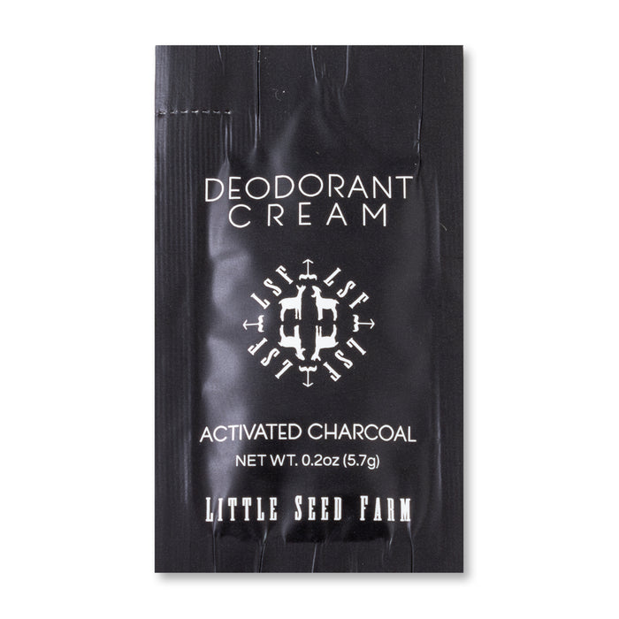 A black packet labeled "Deodorant Cream Sample - Activated Charcoal" shows a net weight of 0.2 oz (5.7g). Aluminum-free, this sample from Little Seed Farm is printed at the bottom.