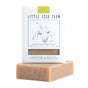 A Matcha & Argan Bar from Little Seed Farm, with a beige, slightly rough texture, rests partly out of its white box featuring the brand name and an illustrated goat.
