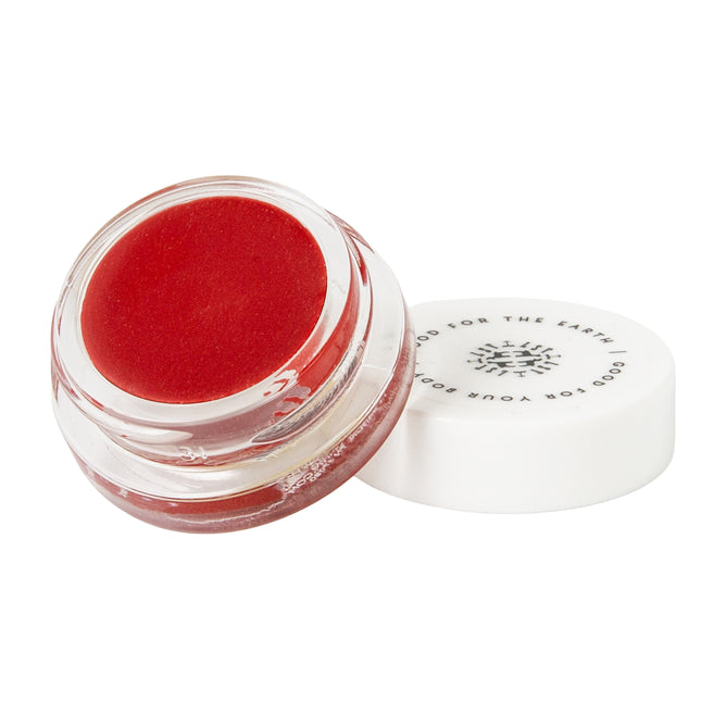 A small, round clear jar of Little Seed Farm Rose Lip Tint with a white lid partially off, showing “GOOD FOR THE EARTH GOOD FOR YOUR BODY” on the lid. Delivers a subtle rosy color for a natural lip tint.