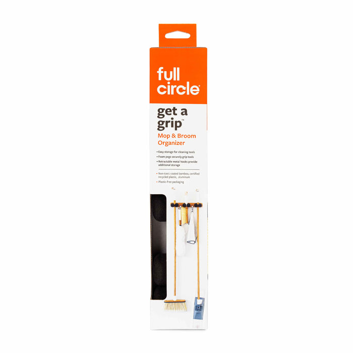 A Full Circle Get a Grip Mop & Broom Organizer in its packaging, featuring an orange and white design with product images and text describing its use for storing cleaning tools.