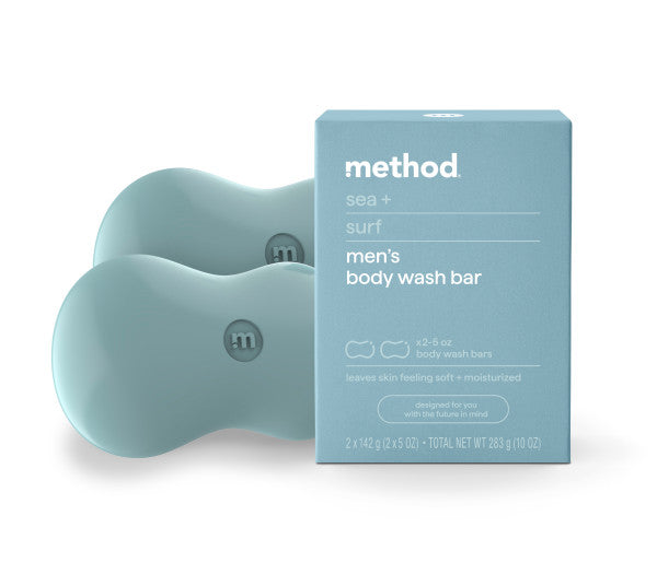 Light blue box labeled method sea + surf mens body wash bar in front of two matching blue, curved body wash bars; packaging highlights moisturizing and softness benefits.