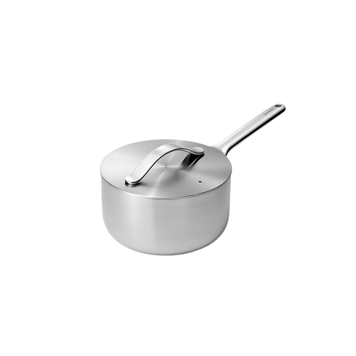 The Caraway Stainless Steel Sauce Pan, 1.75 qt, features a sleek design with a matching lid and curved handle. Its long, sturdy grip includes a hanging hole for convenience. This modern, minimalist cookware is non-toxic and elegantly set against a plain white background.